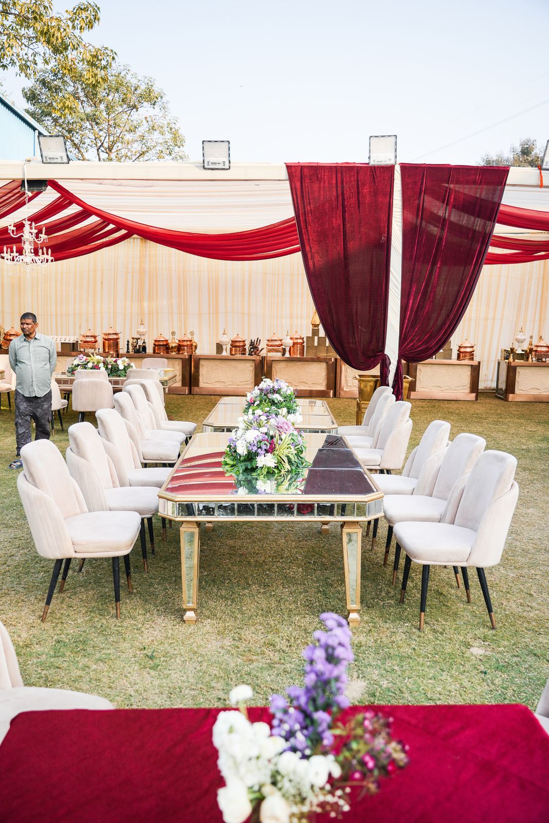 Floral welcome archway at the road-facing entrance of Aarna Farms Noida — Sector-133 wedding venue gateway with crystal chandelier, pampas grass and rose garlands